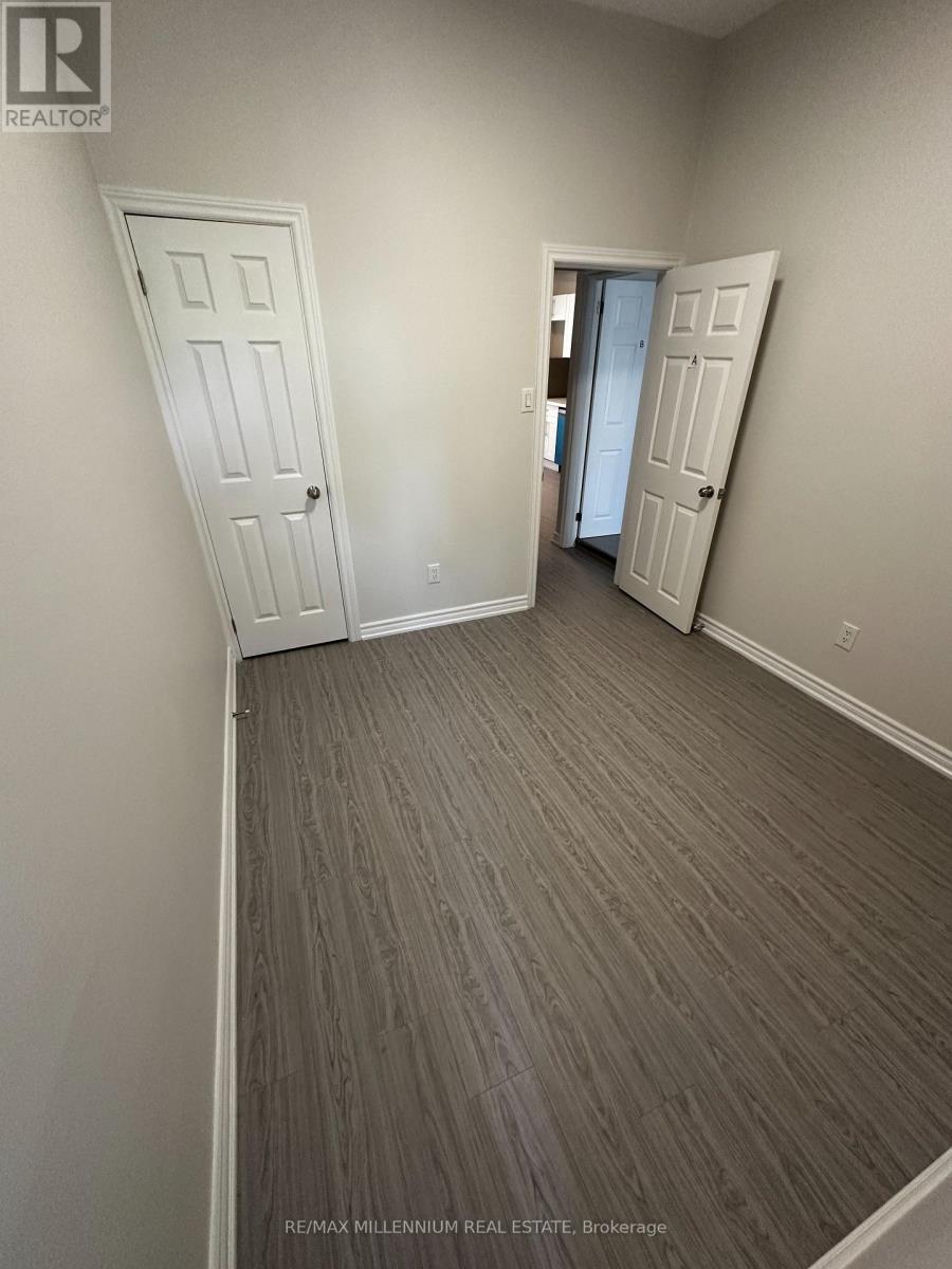 A room with a grey carpet and two white doors.