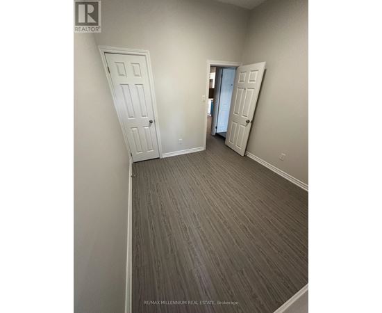 A room with a grey carpet and two white doors.
