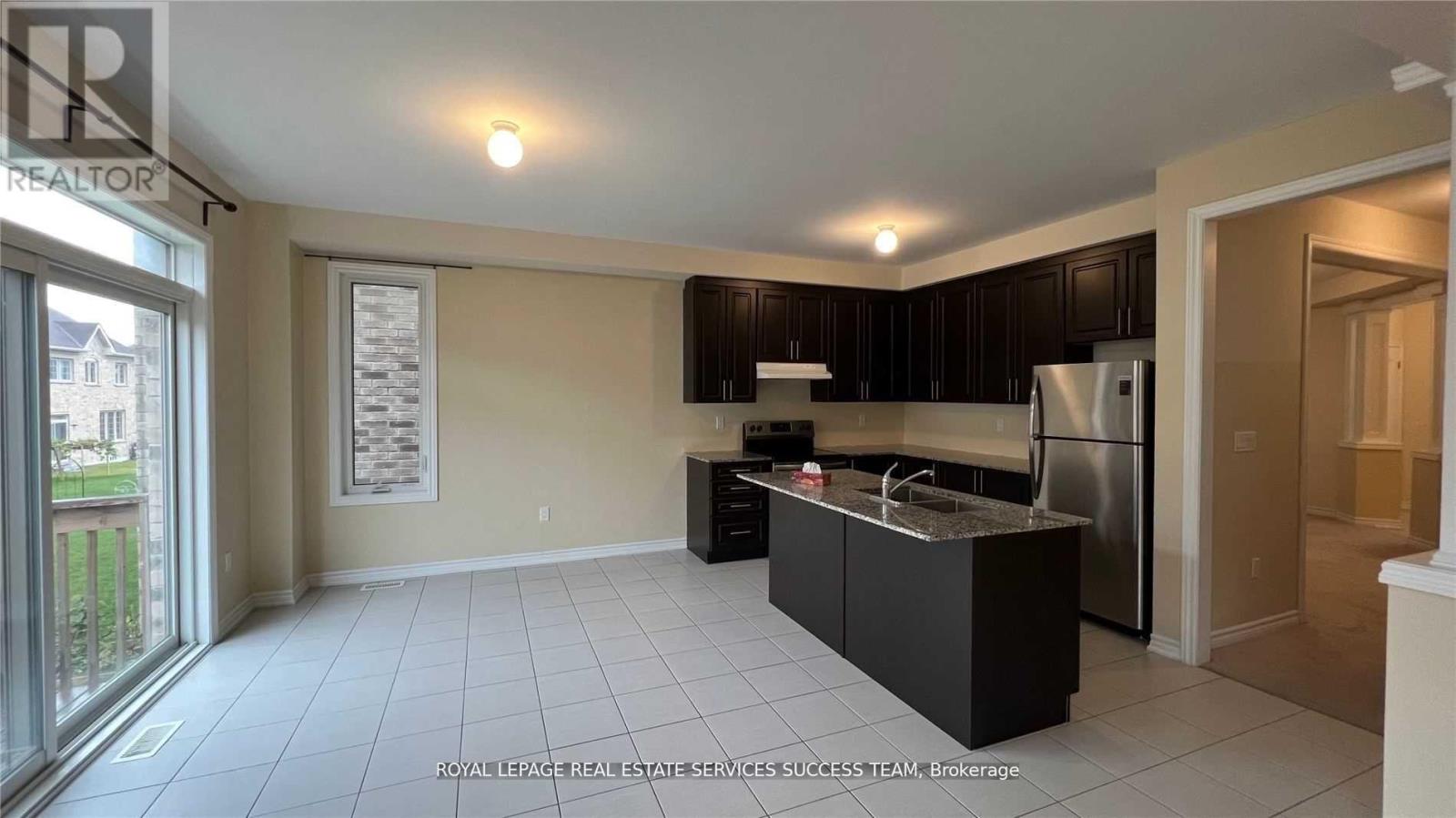 A kitchen with black cabinets and a white fridge.