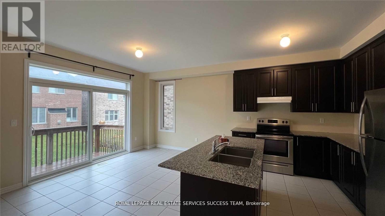 A kitchen with black cabinets and a granite countertop.
