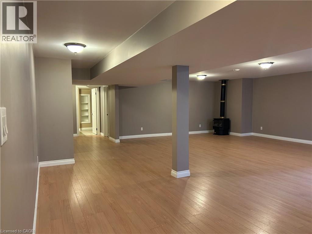 A spacious room with wooden flooring and a large open doorway leading to another room.