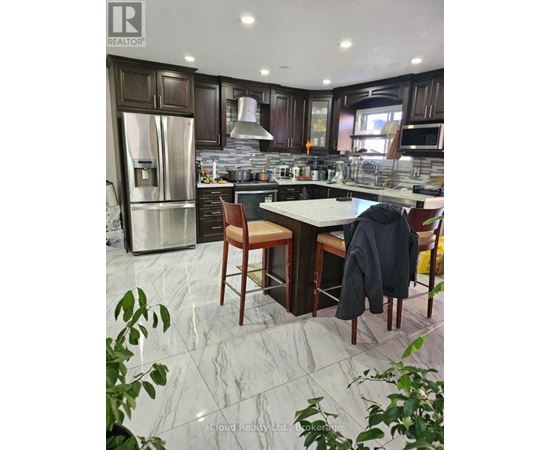 A kitchen with a marble floor and a table with chairs.