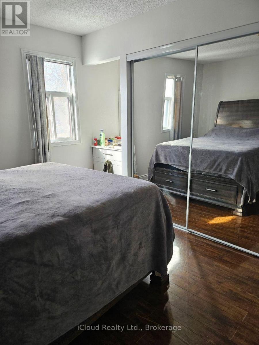 A bedroom with a large bed and a mirrored closet door.