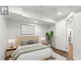 A bedroom with a bed, nightstands, and a plant.