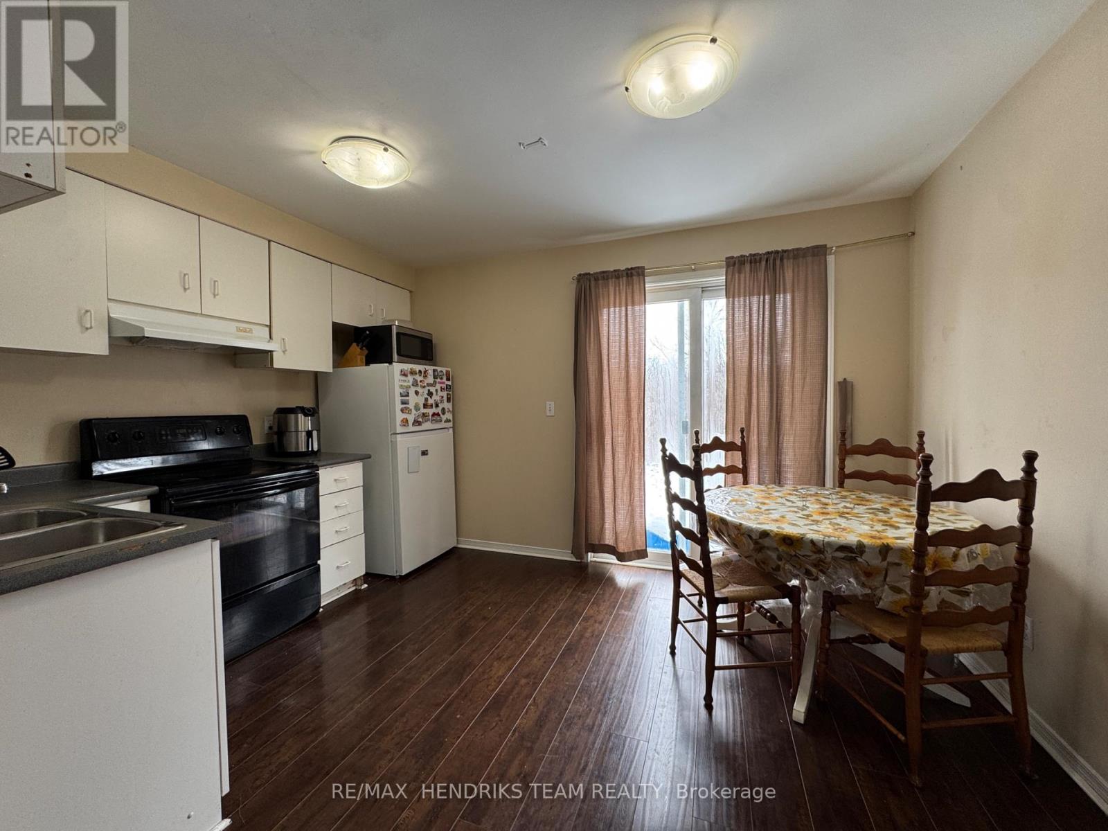 A kitchen with a dining table and chairs in the middle of the room.