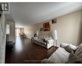 A living room with a striped couch and a lamp.