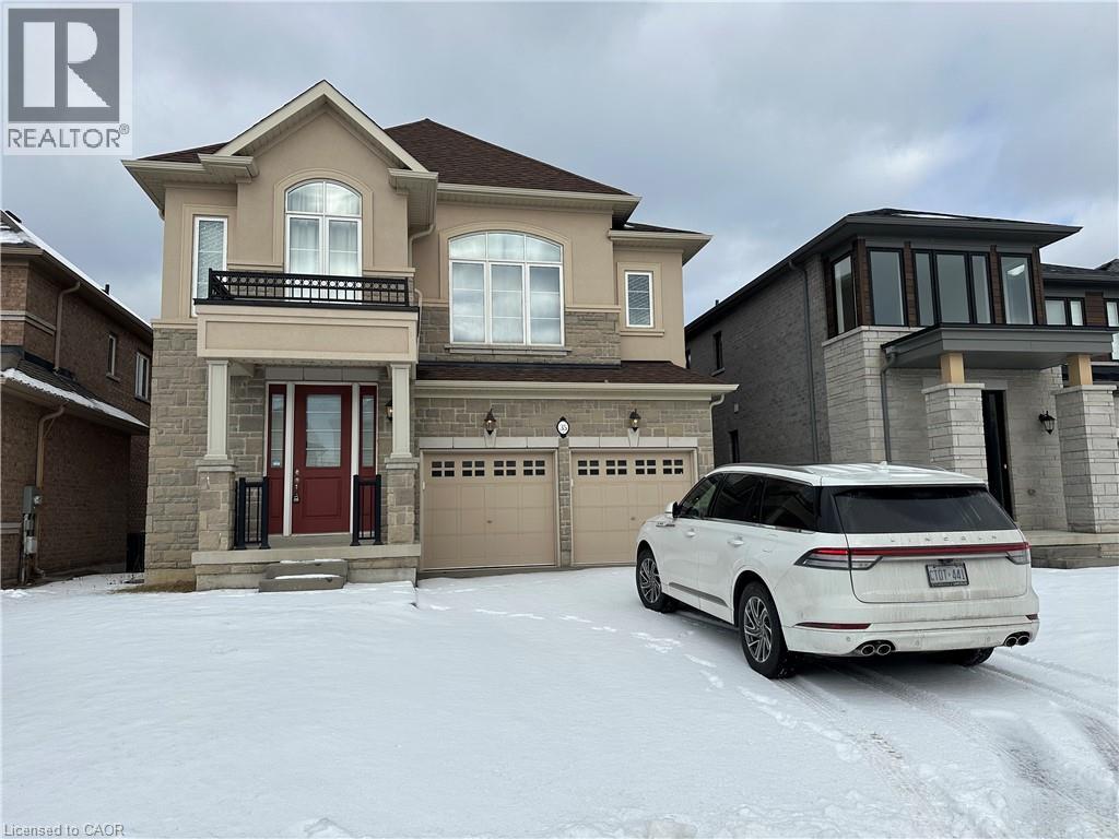 A white car is parked in front of a two-story house.