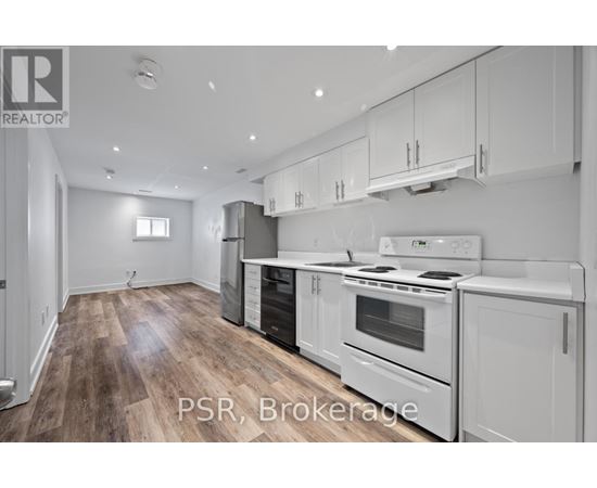 A modern kitchen with white appliances and wooden floors.