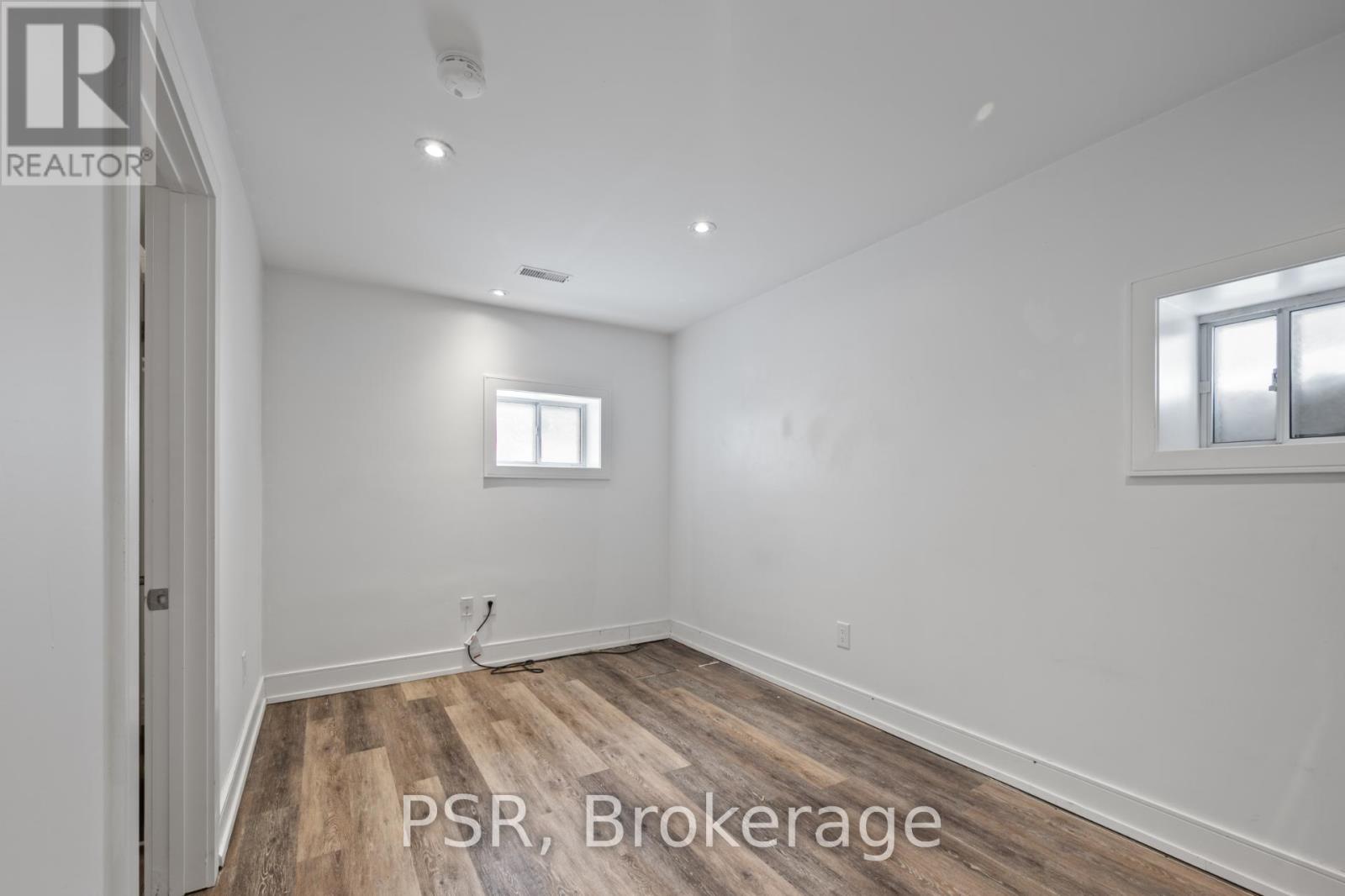 A room with wooden flooring and a window.