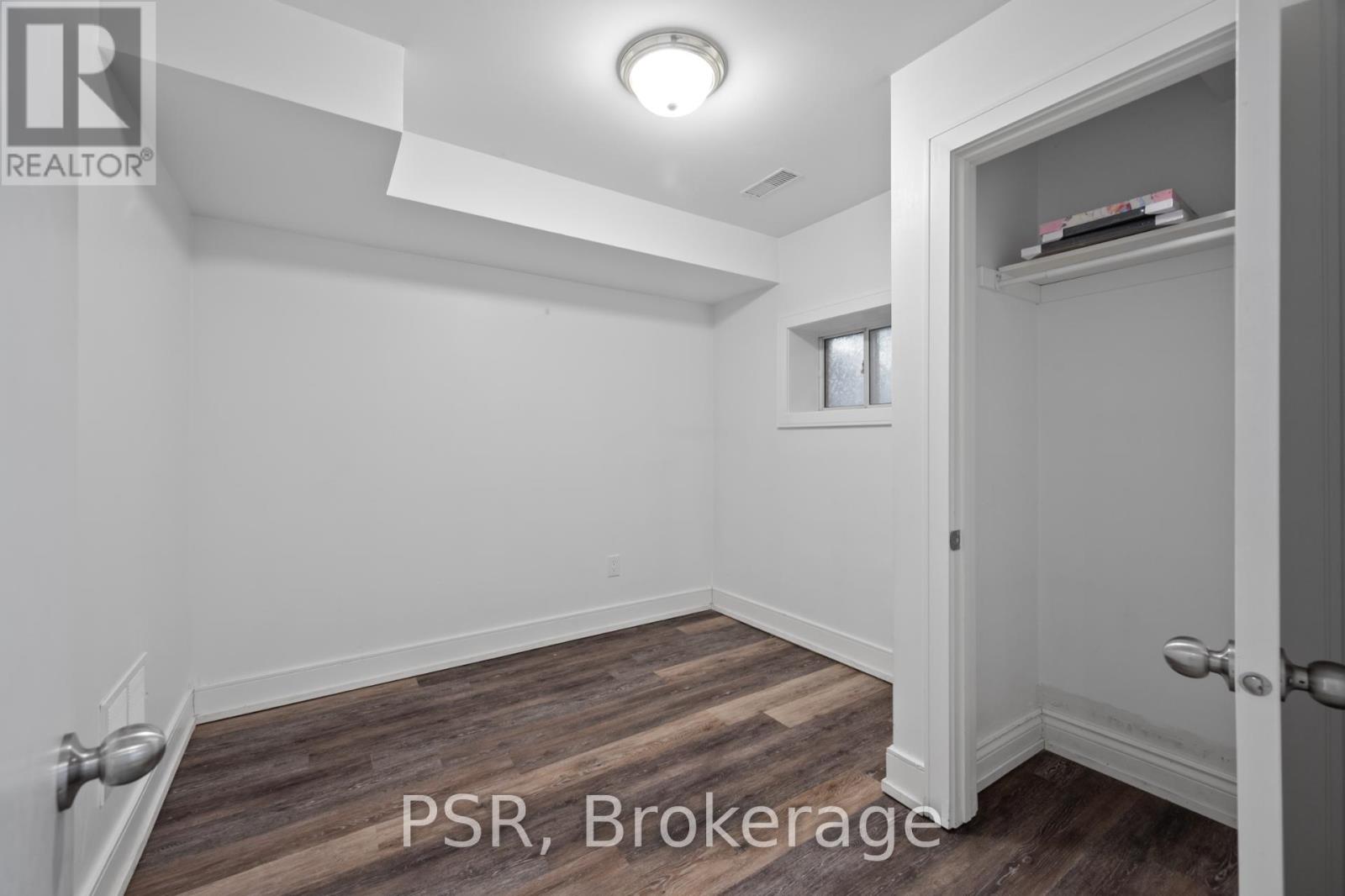 A room with a door and a window with a white wall.