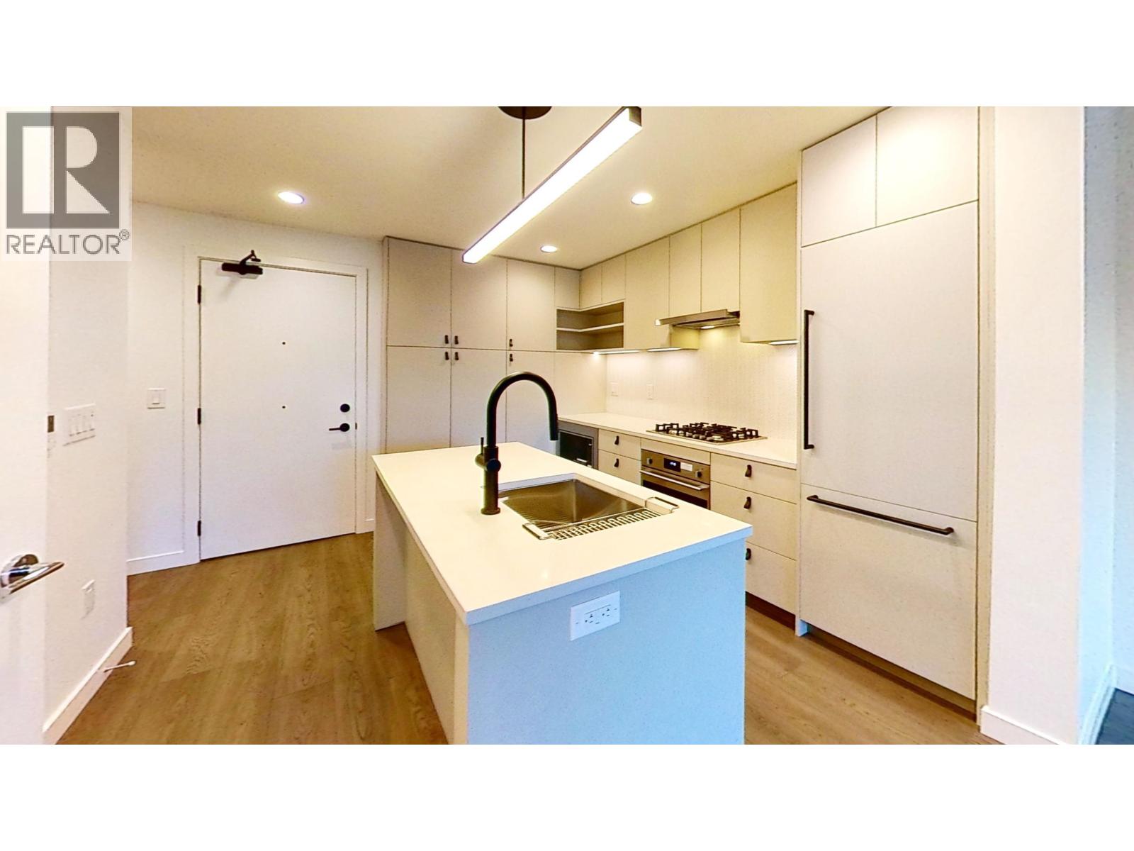A kitchen with a sink and a refrigerator.