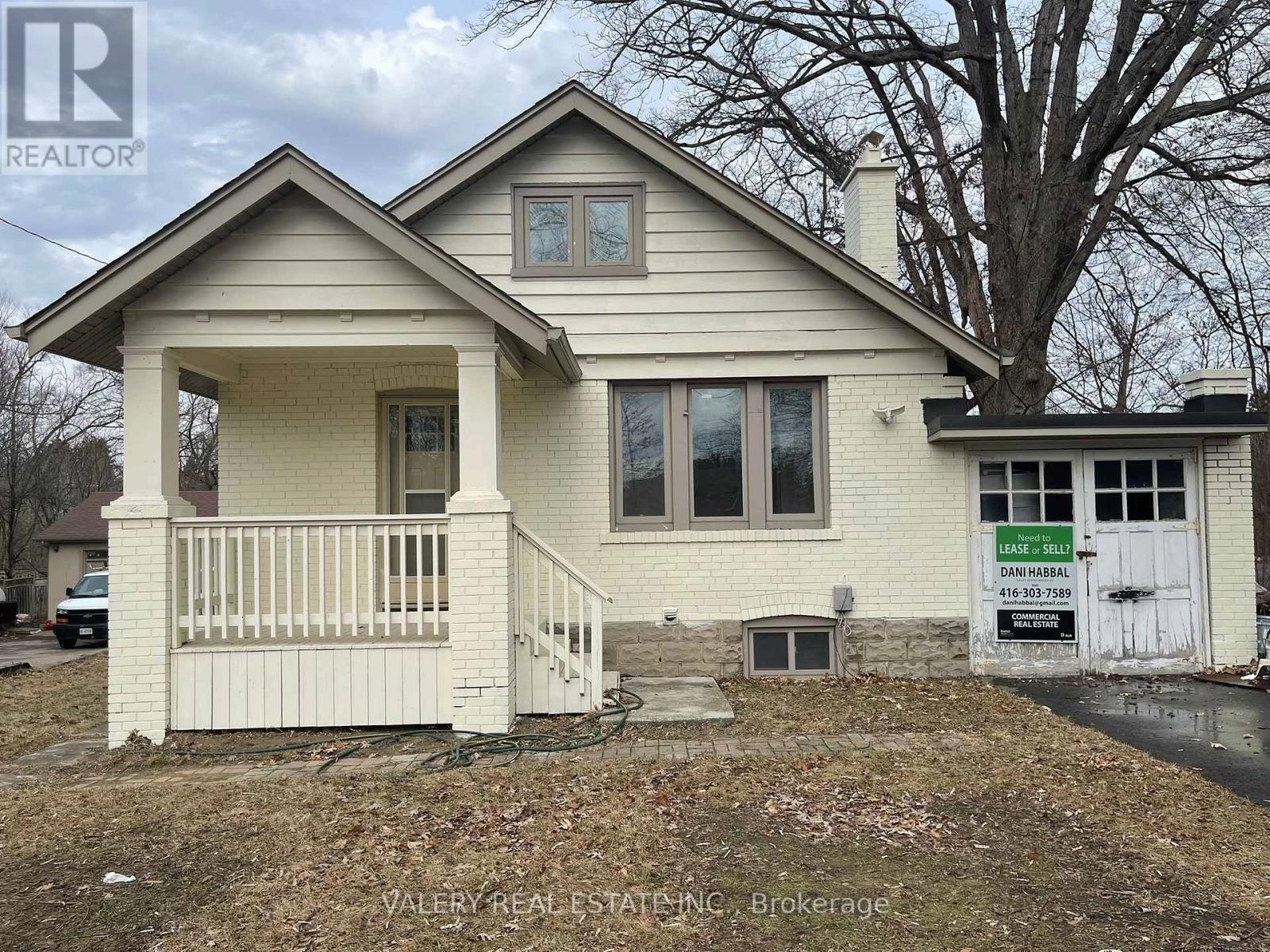 A house with a sign that says "For Sale" in front of it.