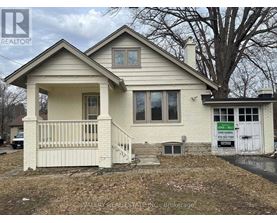 A house with a sign that says "For Sale" in front of it.