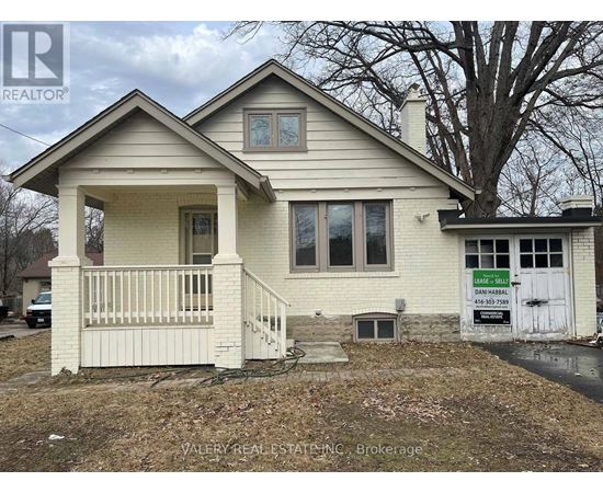 A house with a sign that says "For Sale" in front of it.