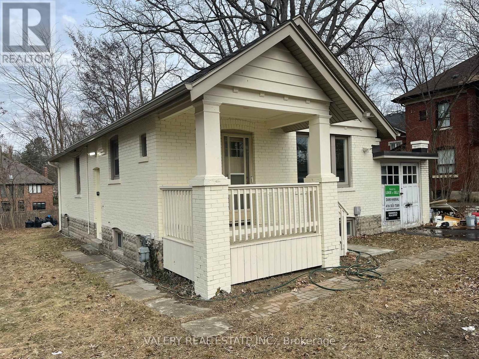 A small white house with a porch is for sale.