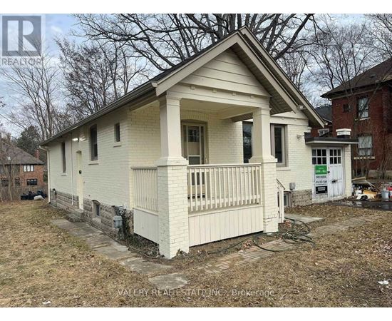 A small white house with a porch is for sale.