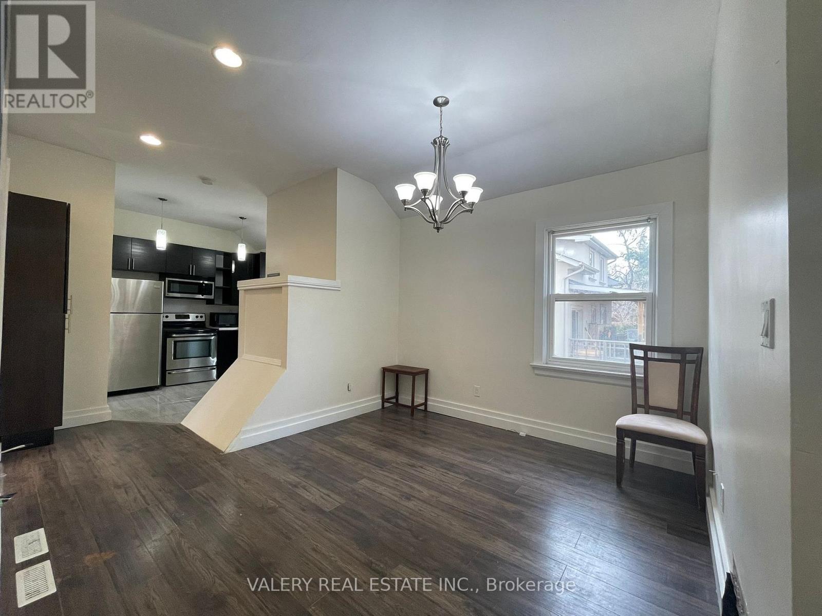 A real estate listing photo of a kitchen and living room.