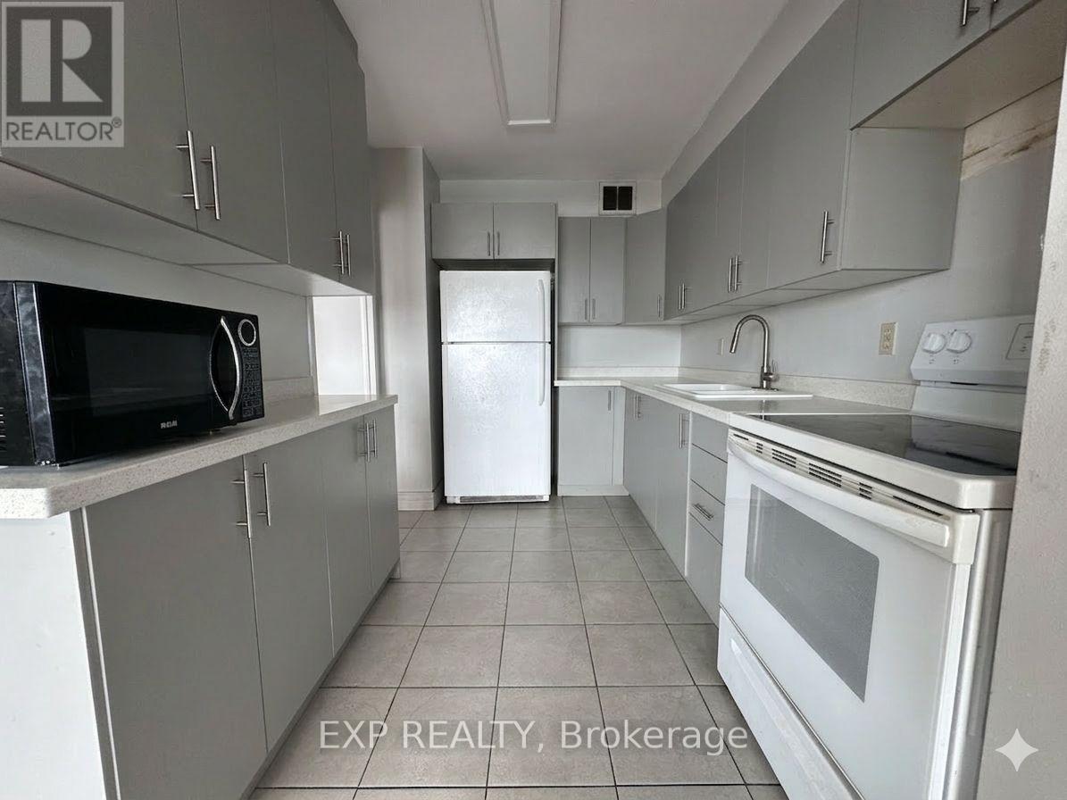 A kitchen with white appliances and grey cabinets.