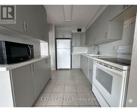 A kitchen with white appliances and grey cabinets.