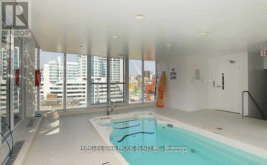 A pool inside a building with a view of the city.