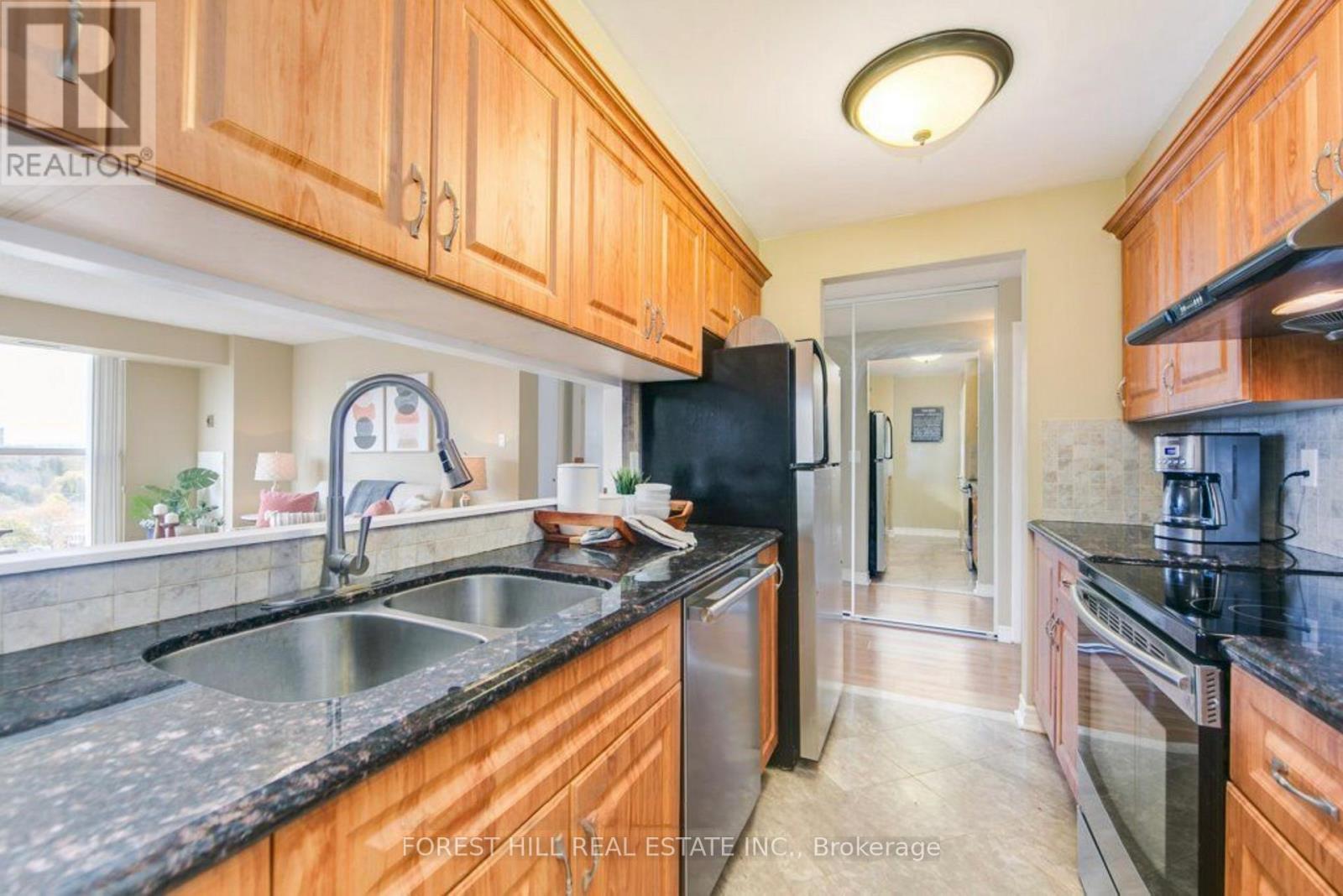 A kitchen with wooden cabinets and black countertops.
