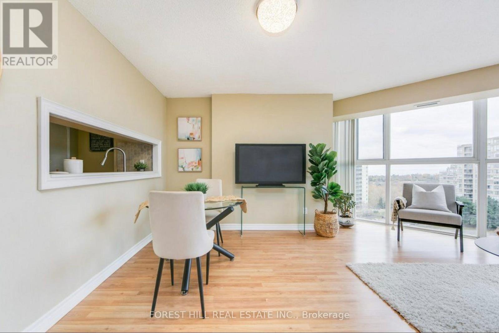 A living room with a white chair and a flat screen TV.