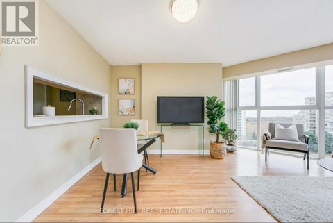 A living room with a white chair and a flat screen TV.