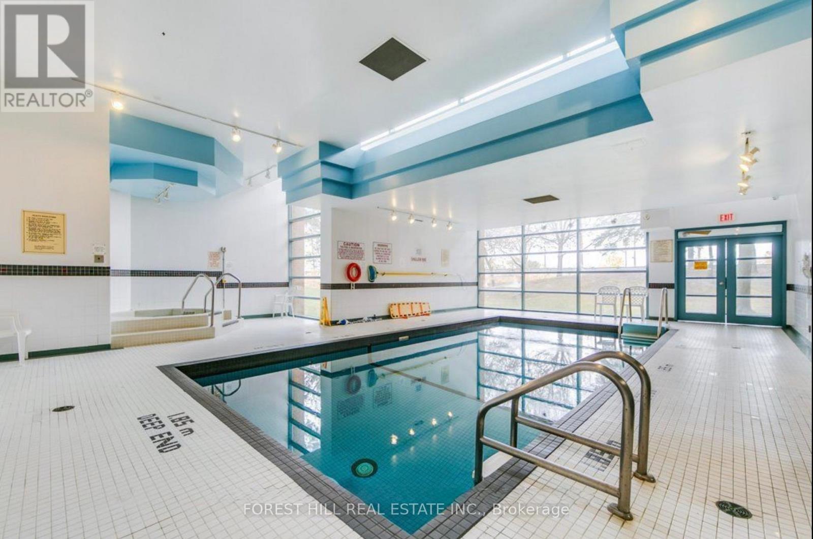 A swimming pool inside a building with a sign that says "REALTOR".
