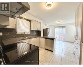 A kitchen with a black countertop and stainless steel appliances.