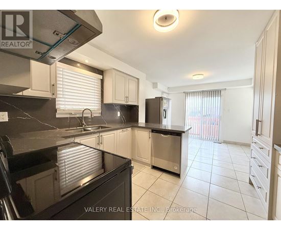 A kitchen with a black countertop and stainless steel appliances.