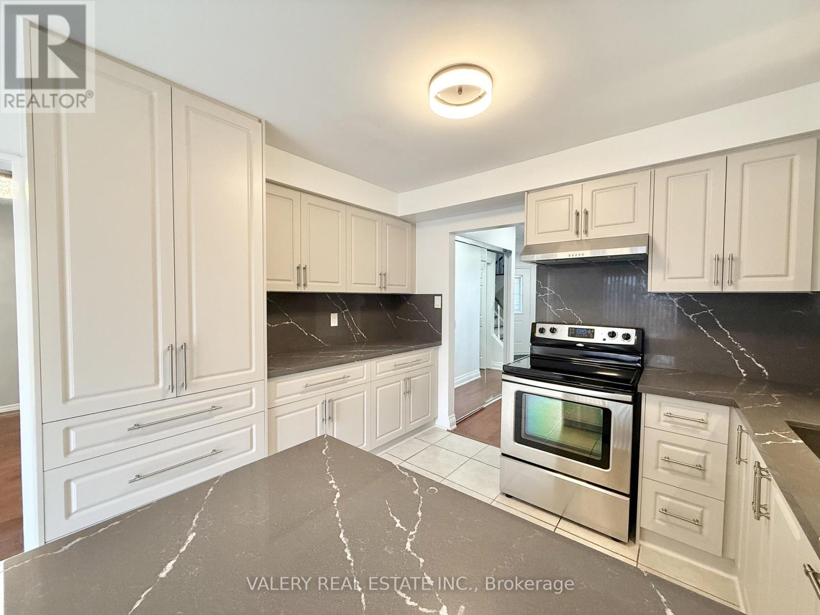 A kitchen with marble countertops and stainless steel appliances.