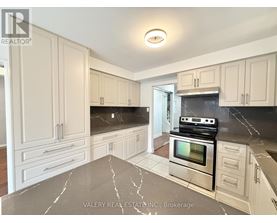 A kitchen with marble countertops and stainless steel appliances.