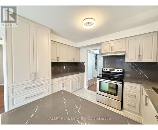 A kitchen with marble countertops and stainless steel appliances.
