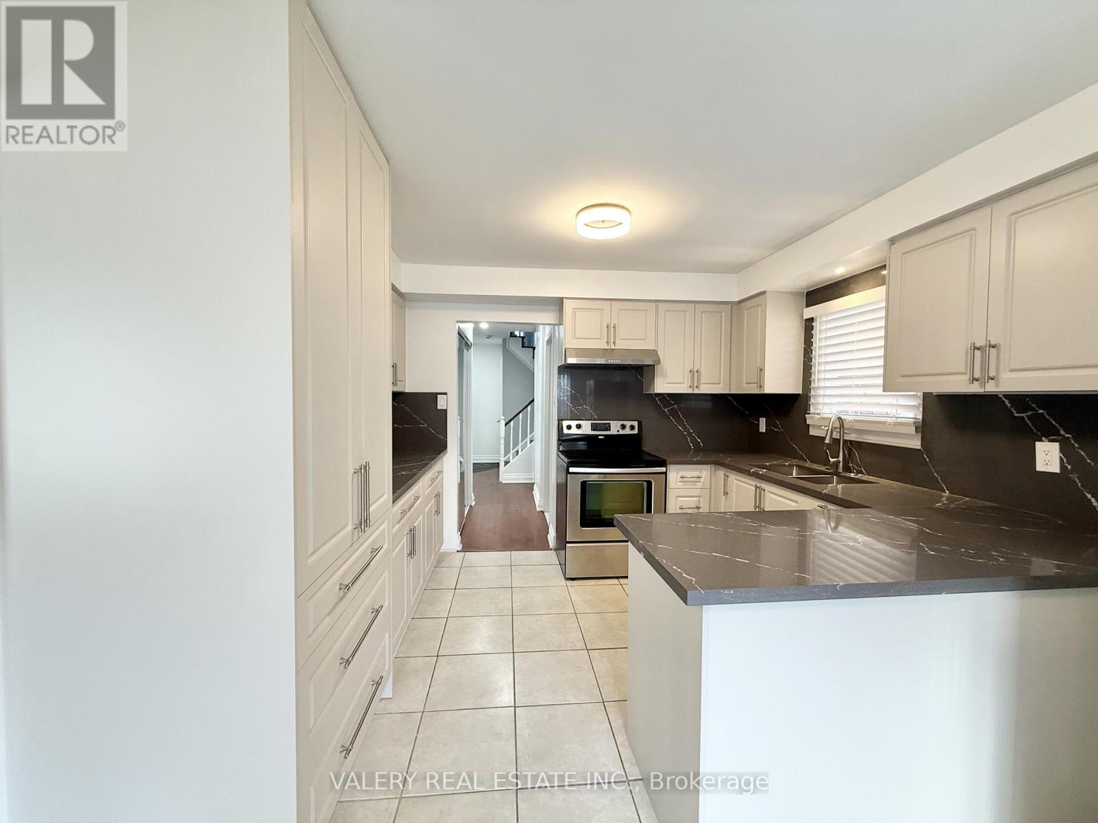 A kitchen with black countertops and white cabinets.