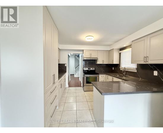 A kitchen with black countertops and white cabinets.