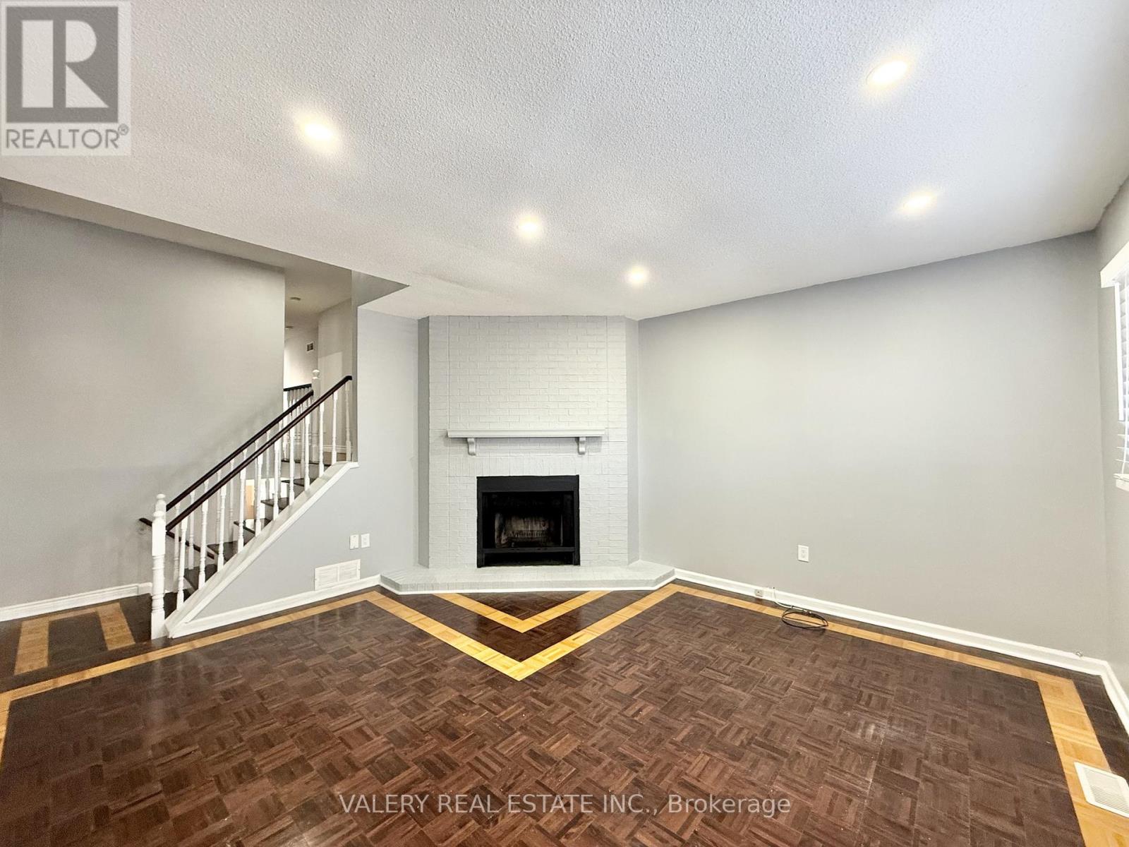 A living room with a fireplace and a staircase.