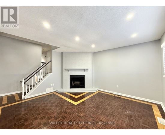A living room with a fireplace and a staircase.