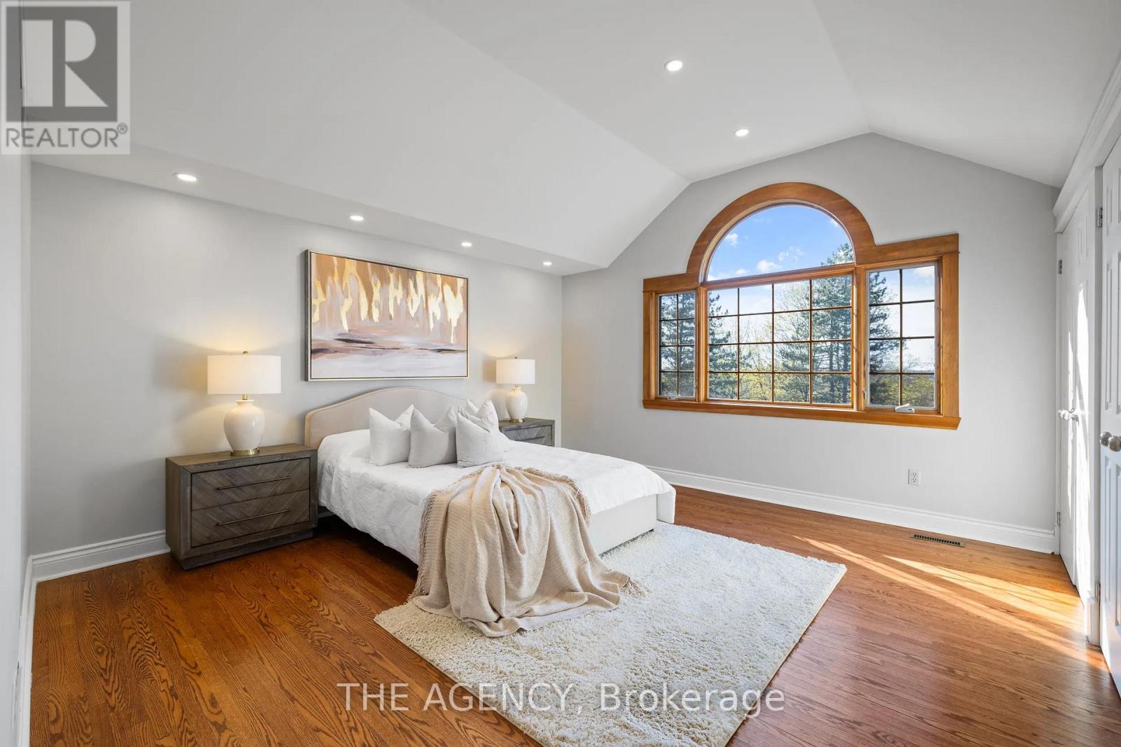 A bedroom with a large bed and a painting on the wall.