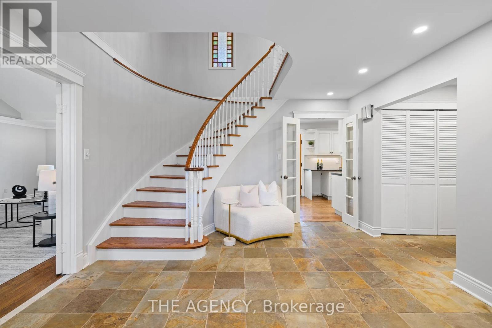 A living room with a couch and a staircase.