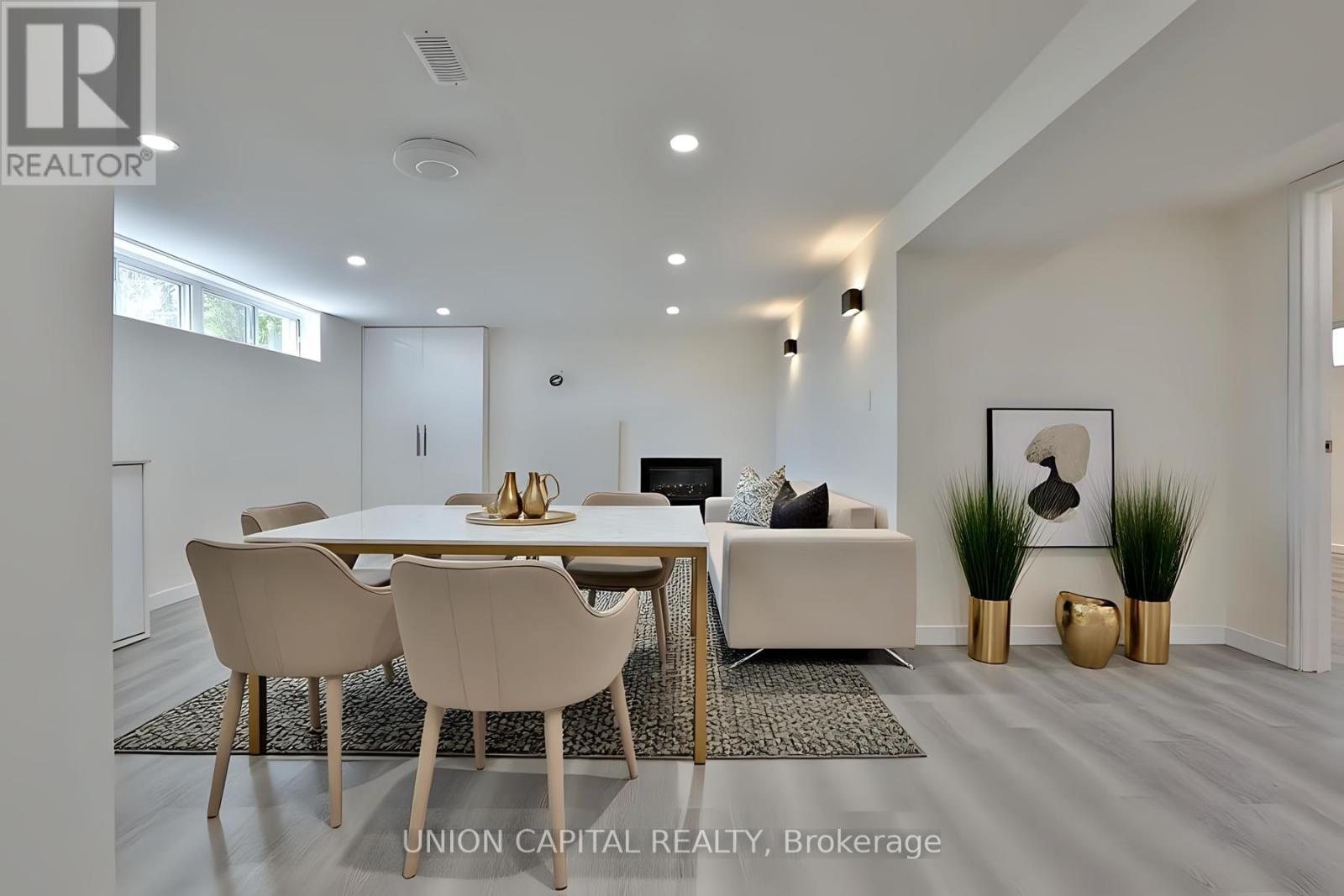 A modern dining room with a white table and chairs.