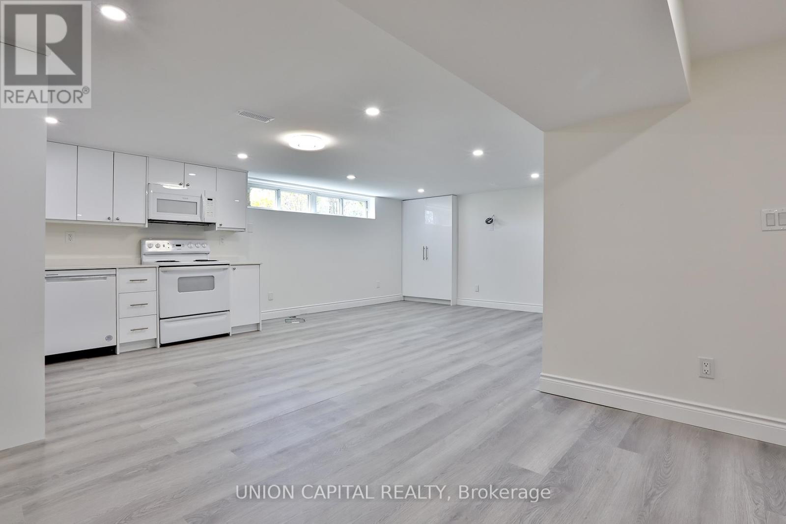 A spacious kitchen with white cabinets and a dining area with a table and chairs.