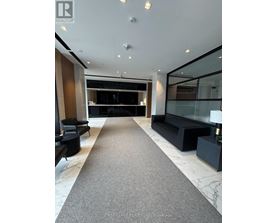 A spacious lobby with a carpeted floor and a glass wall.