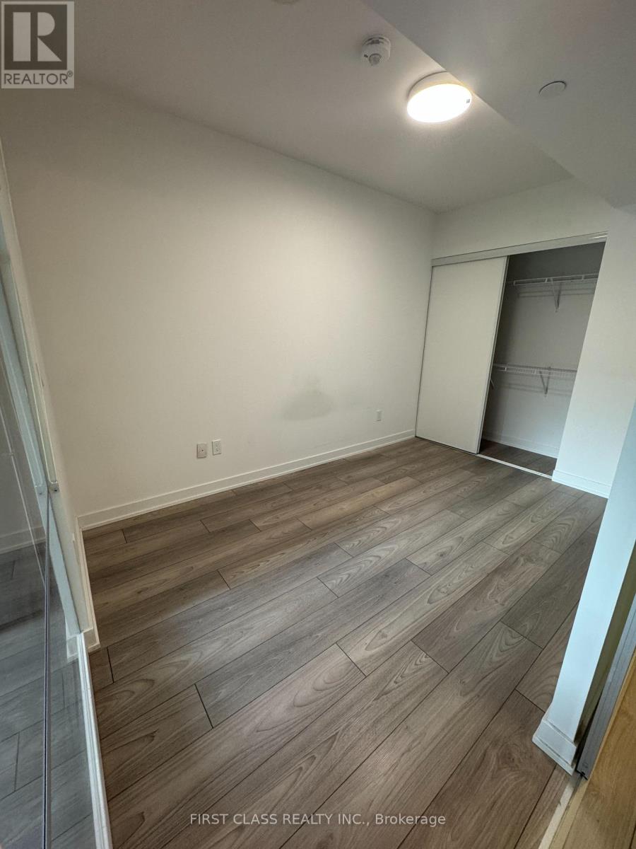 A room with wooden flooring and a white wall.