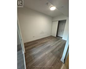 A room with wooden flooring and a white wall.