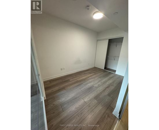 A room with wooden flooring and a white wall.