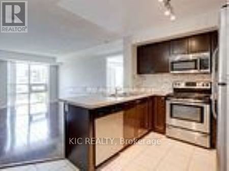 A modern kitchen with stainless steel appliances and wooden cabinets.