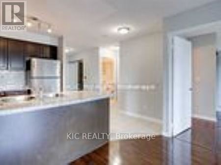 A modern kitchen with stainless steel appliances and wooden flooring.