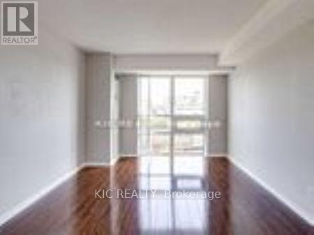 A room with a wooden floor and white walls, with a glass door leading outside.