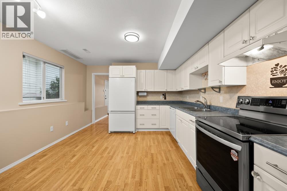 A kitchen with wooden floors and white appliances.