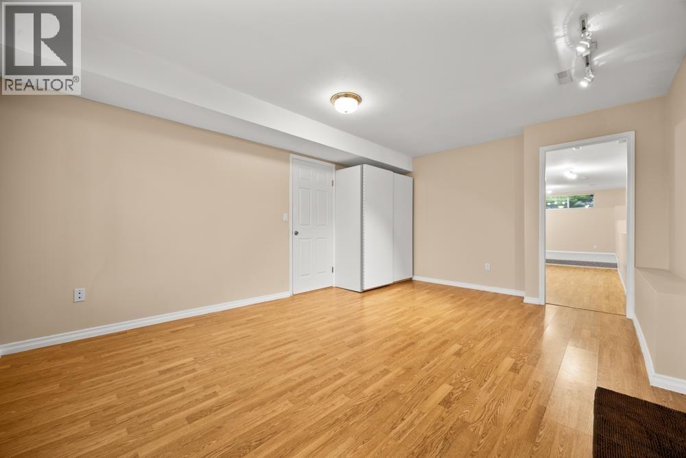 A room with wooden flooring and a white ceiling with a light fixture.